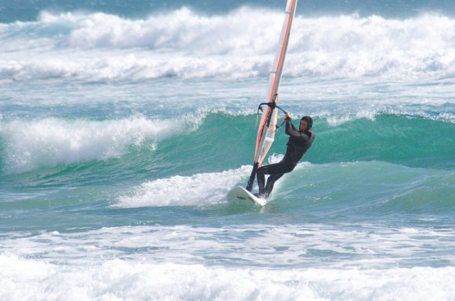 cogiendo las olas mientras windsurfea